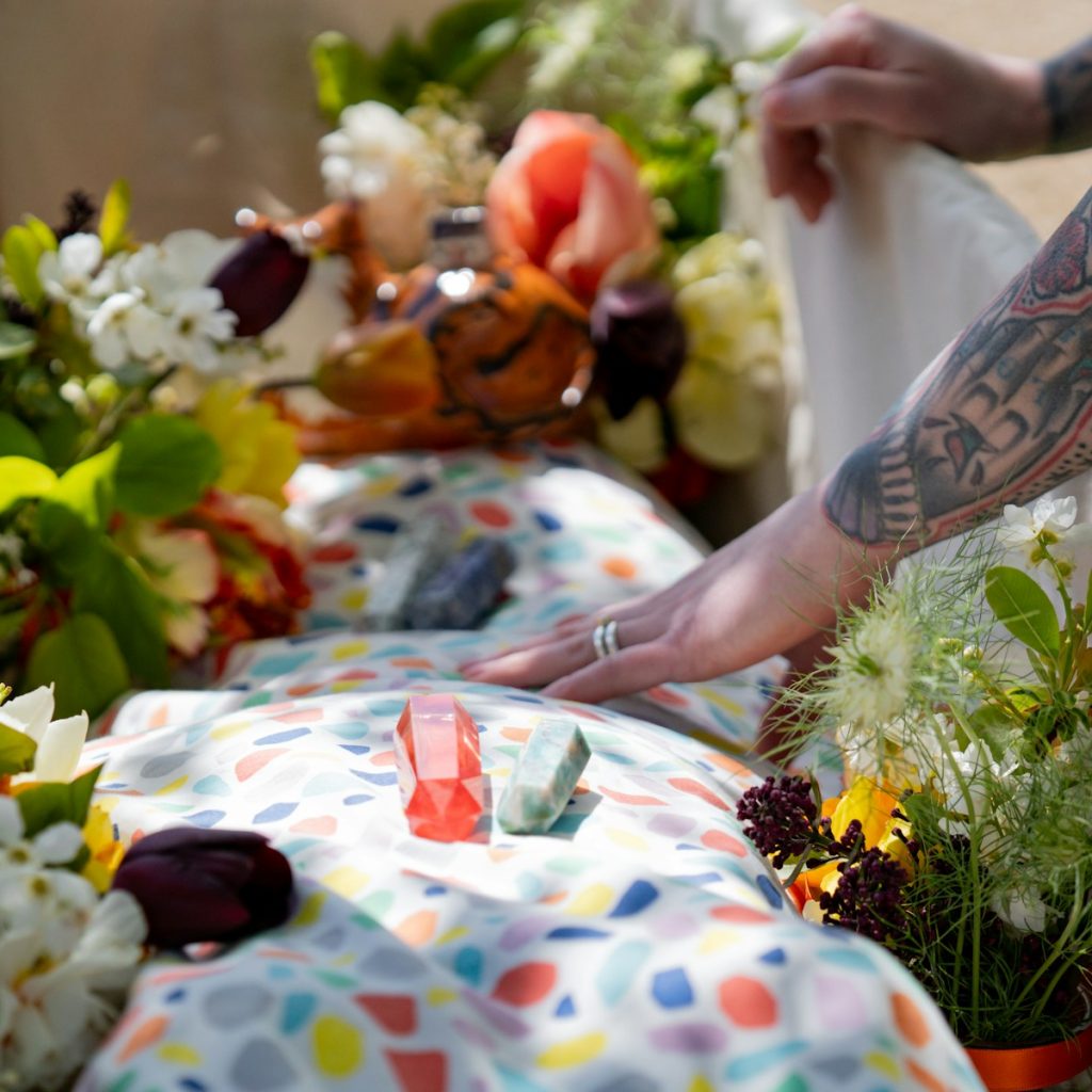 a person reaching for a flower on a table