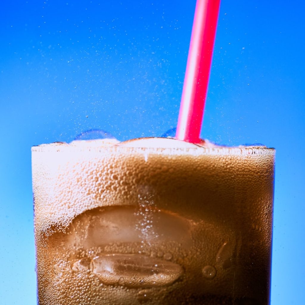 clear drinking glass with ice and red straw