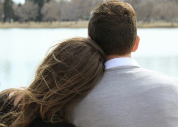 Man and woman sitting by the water
