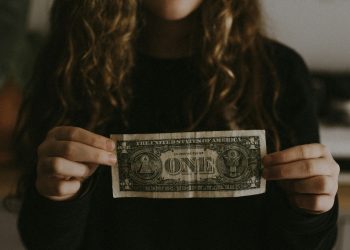 Woman holding one dollar bill