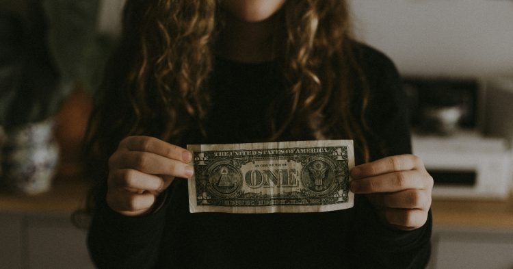 Woman holding one dollar bill
