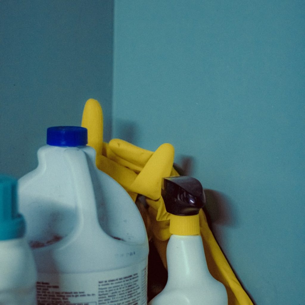 A close up of a bottle of cleaner next to a mirror