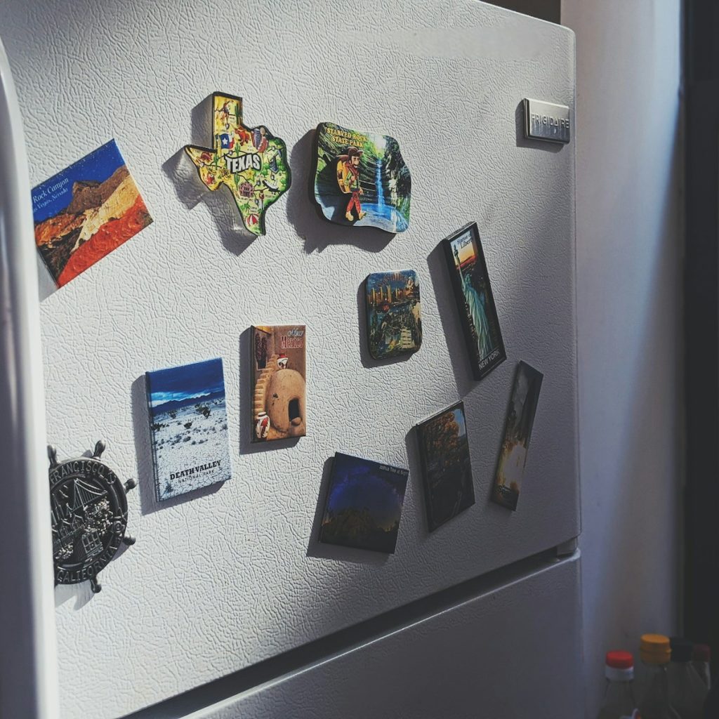 gray top mount refrigerator with stickers