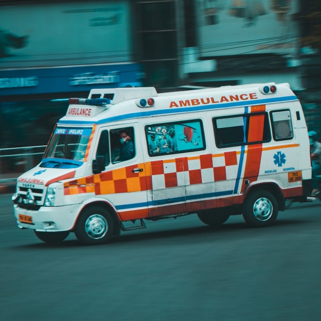 an ambulance driving down a street next to tall buildings