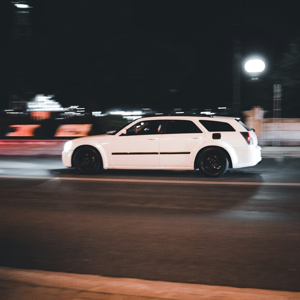 a white car on a road at night
