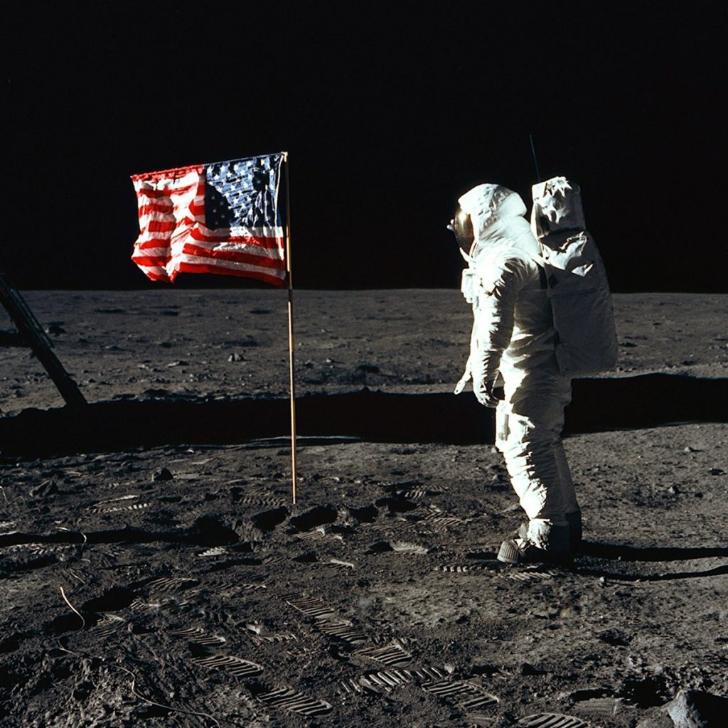 Buzz Aldrin on the moon in front of the US flag