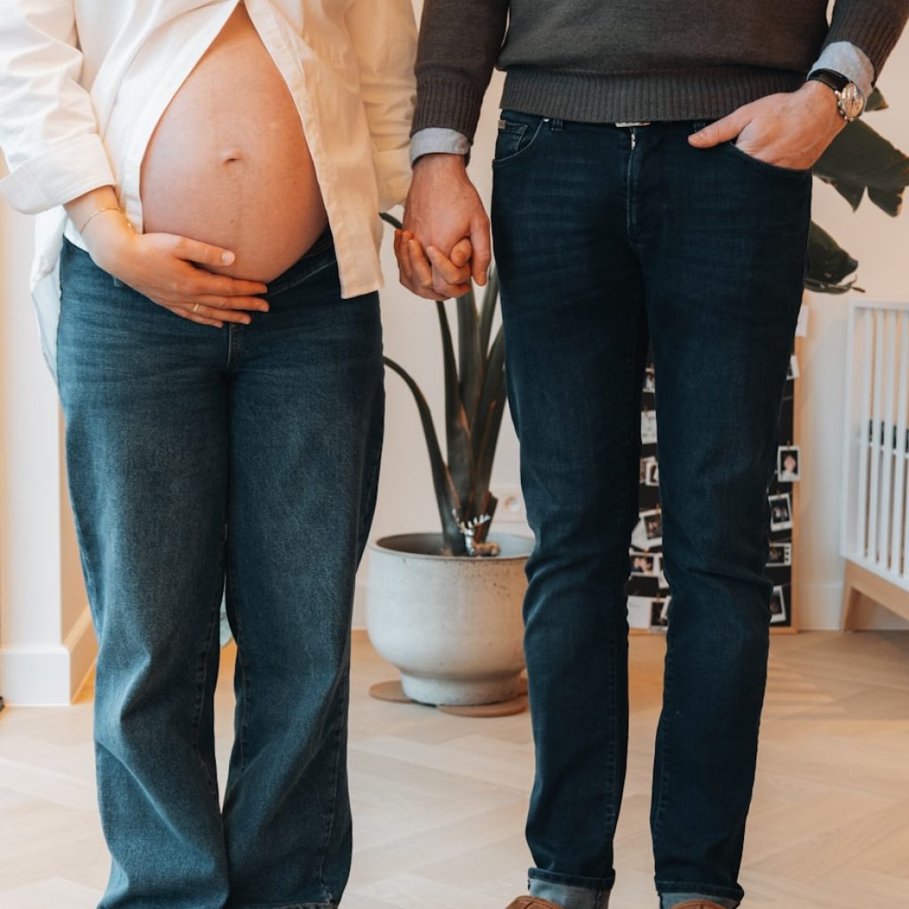 a pregnant woman standing next to a man