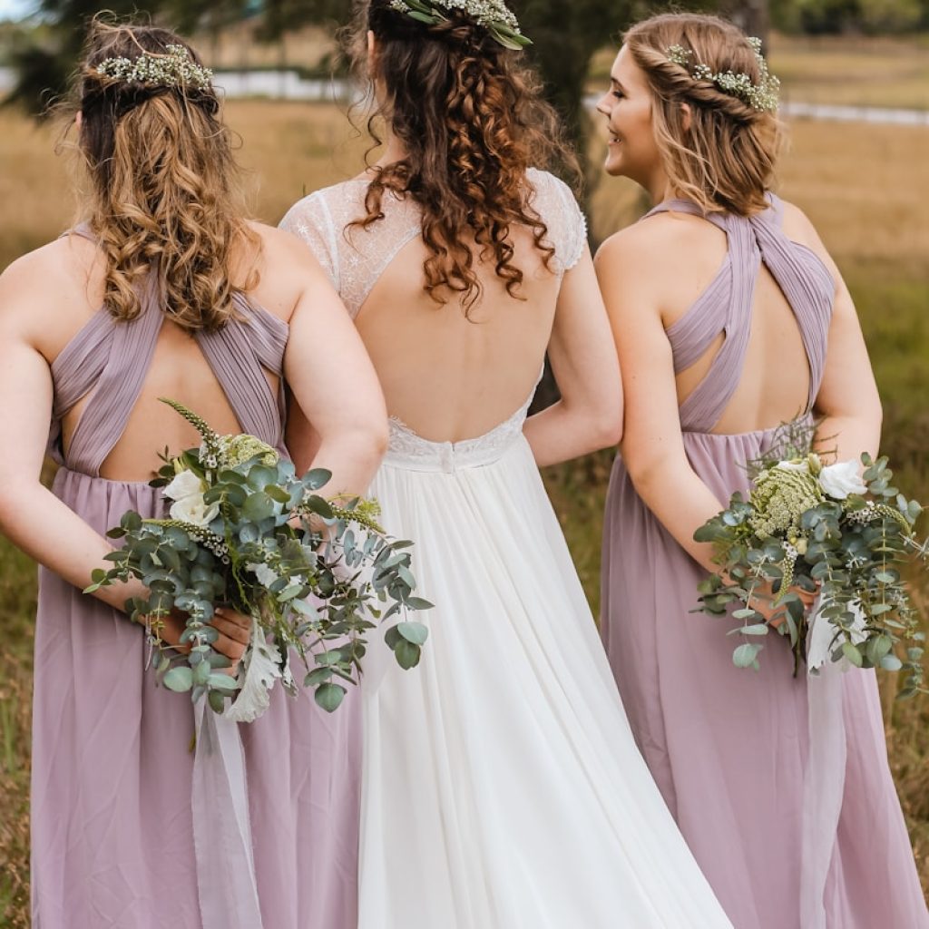 three women hiding flower bouquets