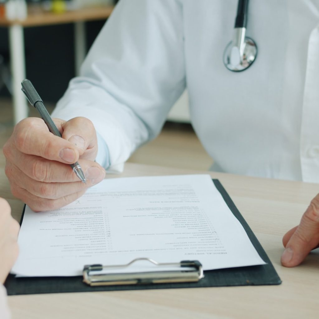 Doctor writing on a patient's chart