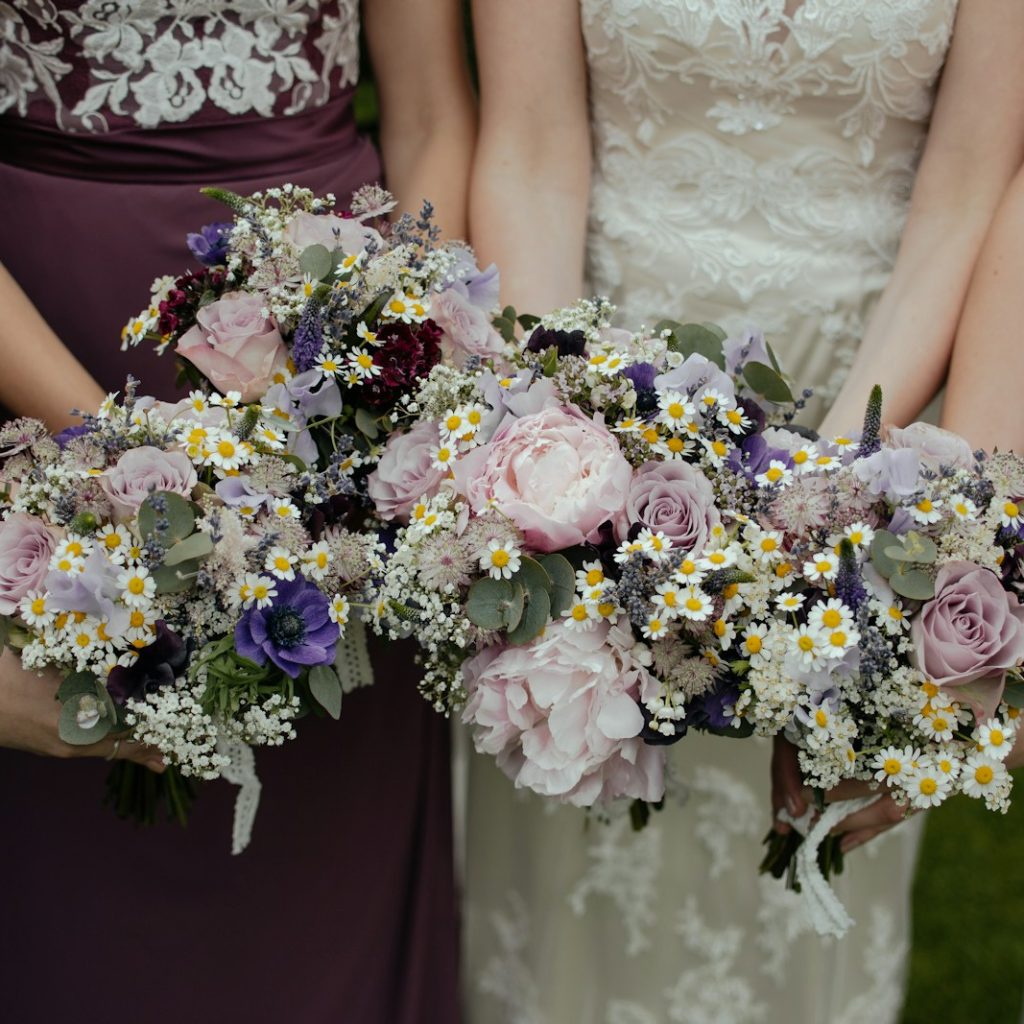 four women carrying bouquet of flowers