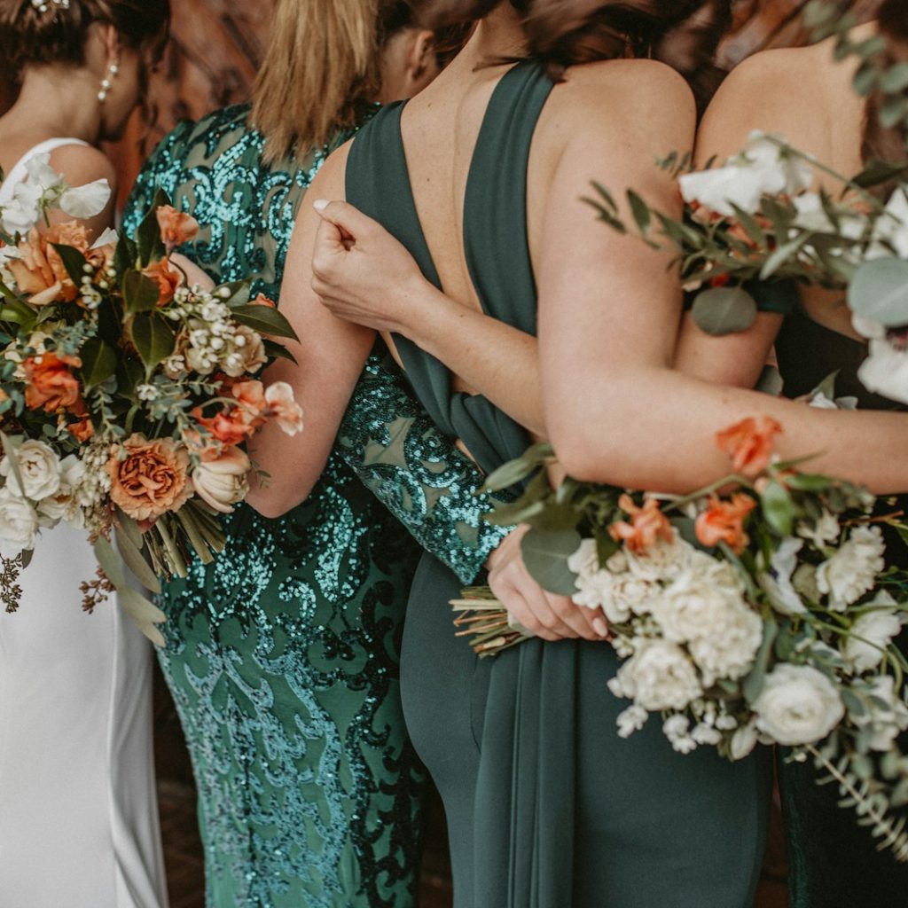 a group of women standing next to each other holding bouquets