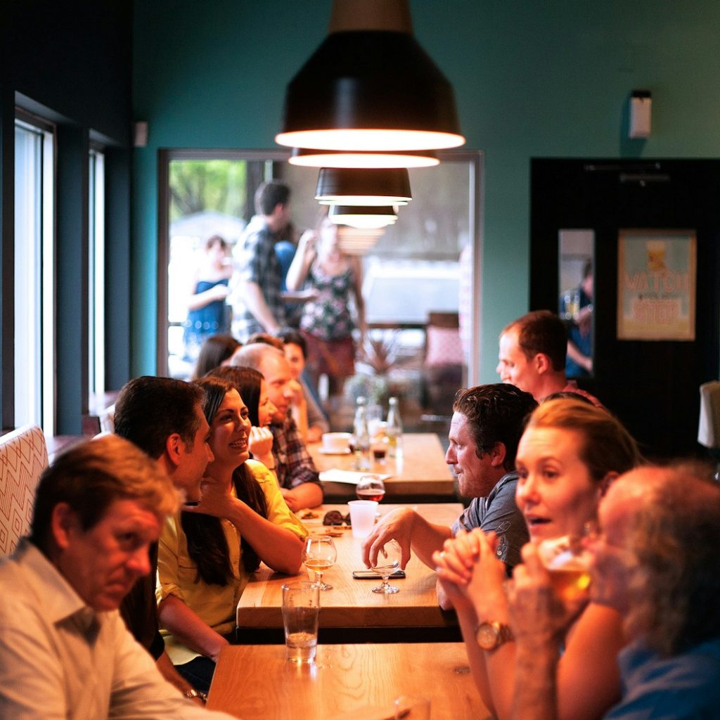 people sitting beside brown wooden table inside room