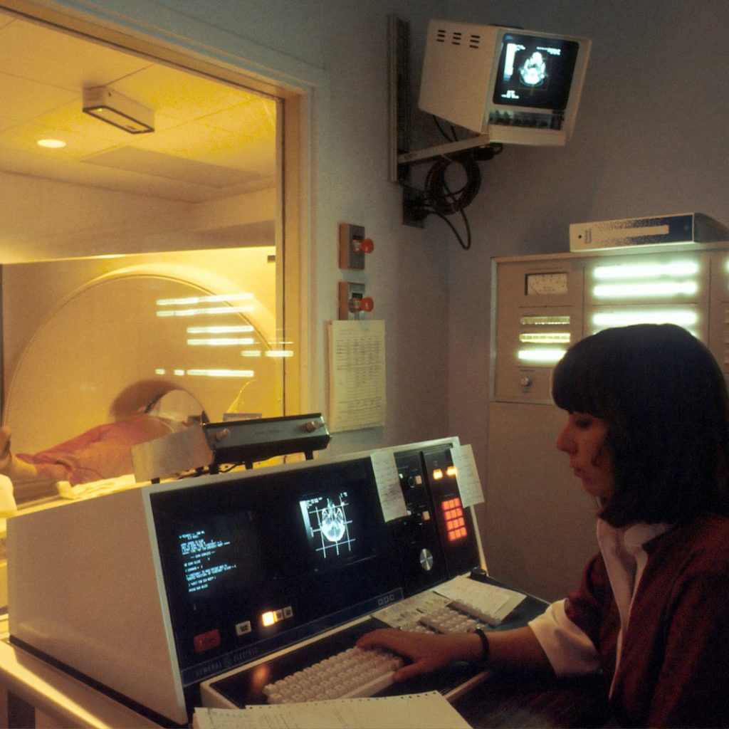 woman in red shirt sitting in front of computer
