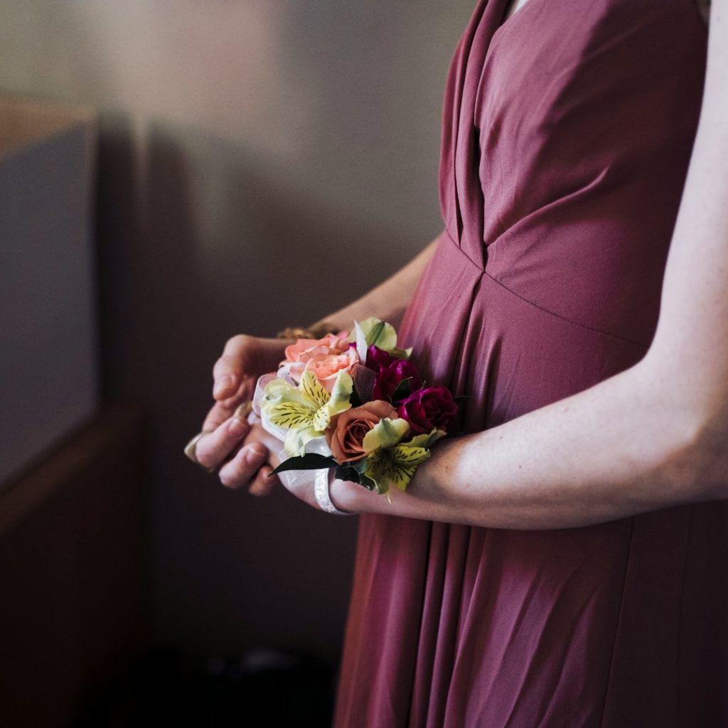 woman in pink dress holding bouquet of flowers