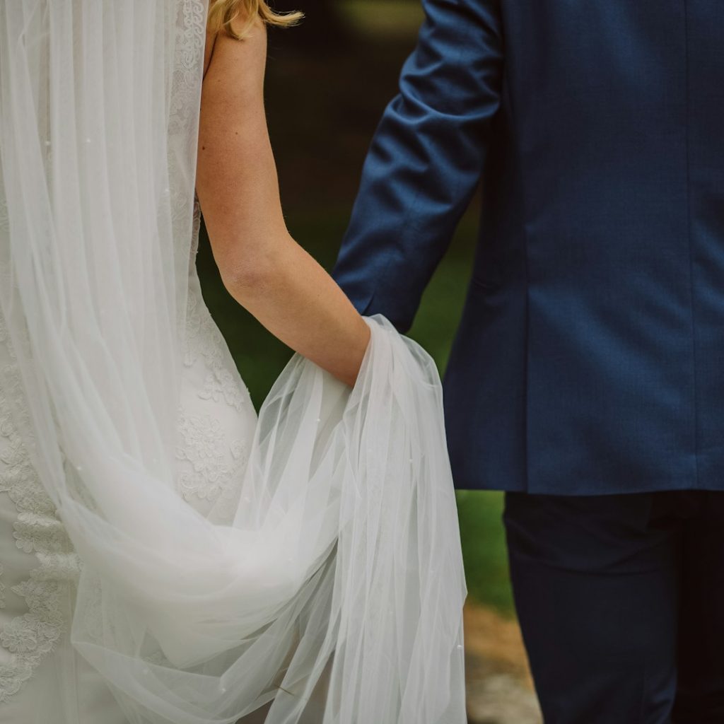 wedding couple holding hands while walking