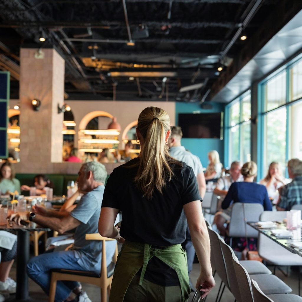 A group of people sitting at tables in a restaurant