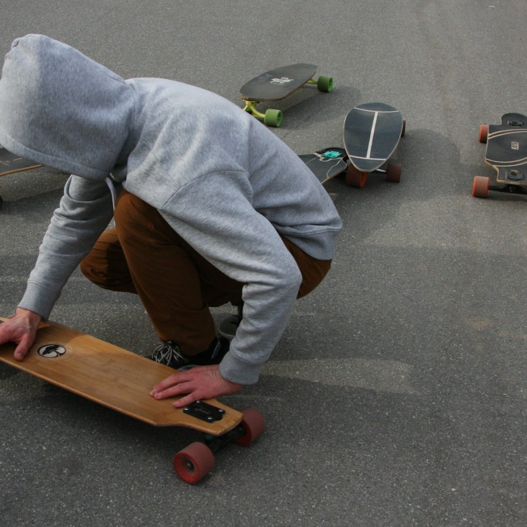 A person kneeling down on a skateboard in the street